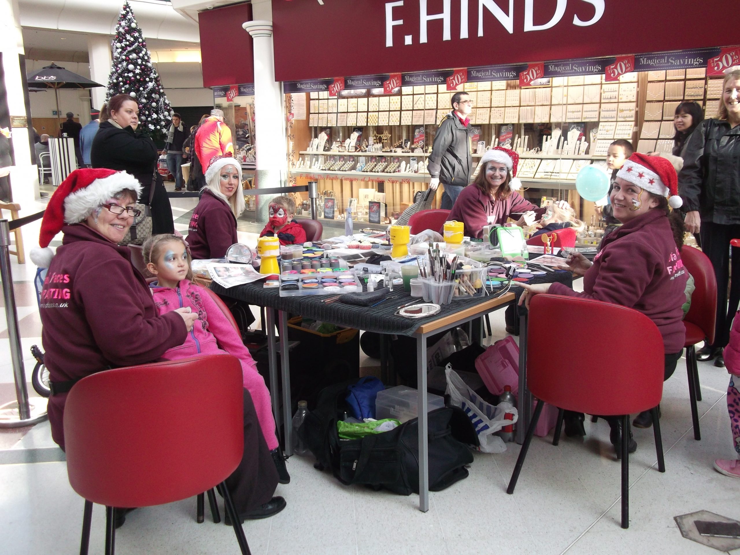 The team wearing Christmas hats hard at work in a shopping centre